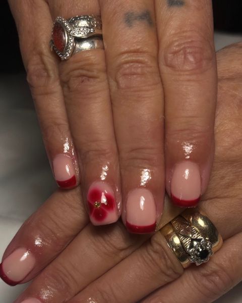 Red French tip gel nails with a hand painted red flower accent